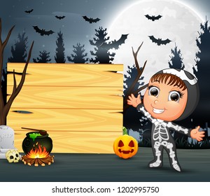 Happy kid wearing skeleton costume stand beside the wooden board