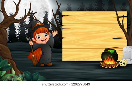 Happy kid wearing witch costume stand beside the wooden board