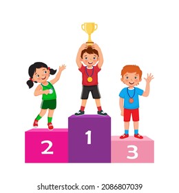 Happy kids with medals holding up gold cup trophy standing on winners podium or pedestal  with first, second and third place prize celebrating winning competition