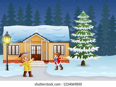 Happy kids playing in front of the snowing house