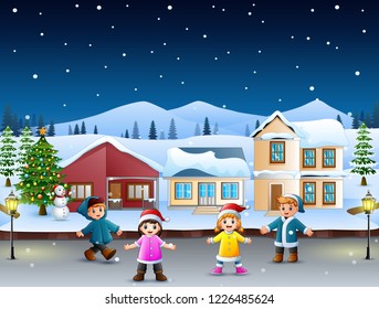 Happy kids playing in front of the snowing village on the christmas day