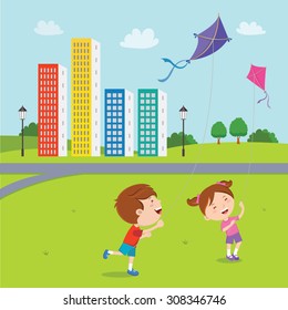 Happy kids playing kites. Children flying kites on the field of apartment buildings.