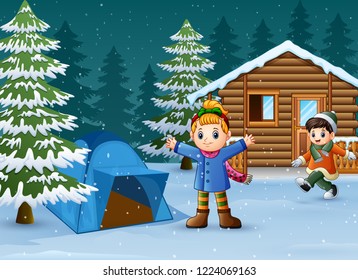 Happy kids to wear winter clothes and play in front of a snowy wooden house