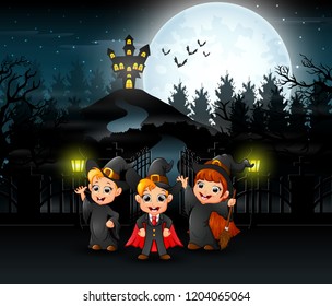 Happy kids wearing halloween costume outdoors with the haunted house background