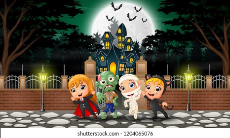 Happy kids wearing halloween costume outdoors with the haunted house background