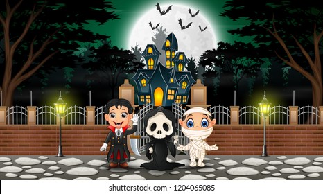 Happy kids wearing halloween costume outdoors with the haunted house background