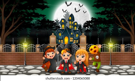 Happy kids wearing halloween costume outdoors with the haunted house background