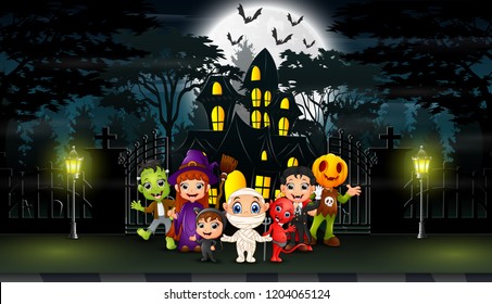 Happy kids wearing halloween costume outdoors with the haunted house background