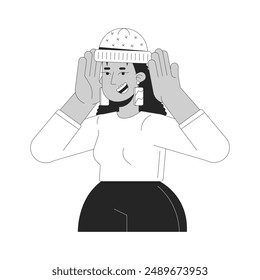 Happy latin american woman putting on hat black and white 2D line cartoon character. Hispanic female with winter accessory isolated vector outline person. Fashion monochromatic flat spot illustration