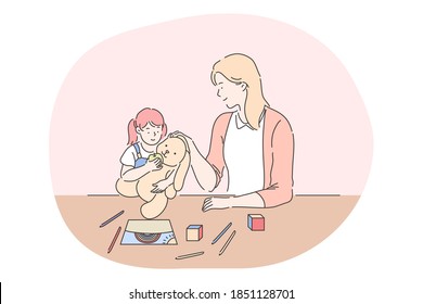 Happy leisure and activities at home with children concept. Young woman mother cartoon character playing, drawing and feeding toy together with her small daughter at home. Relax, rest, family