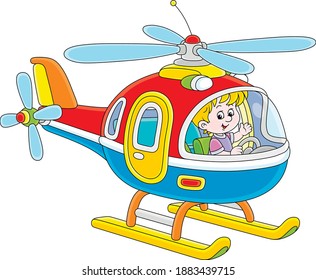 Happy little boy playing and piloting a big and colorful toy helicopter on a playground, vector cartoon illustration on a white background