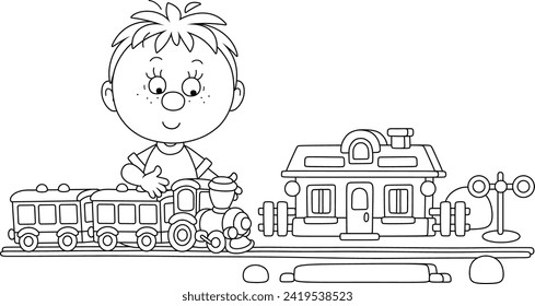 Niño feliz jugando con un tren de juguete y una estación en su sala de juegos, ilustración vectorial de contorno negro y blanco para un libro de colores