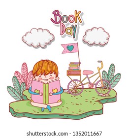 happy little boy reading book with bicycle in the field