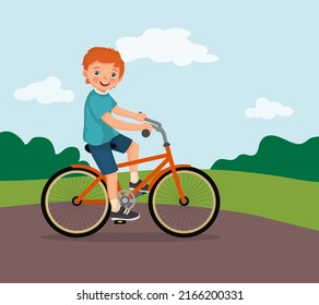 happy little boy riding a bike having fun in the park sunny day 