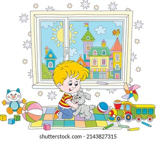 Happy little boy romping and playing with his merry puppy among colorful toys in a nursery room with a pretty small town outside a window, vector cartoon illustration isolated on a white background
