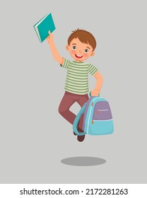 Happy little boy student holding backpack and book jumping feeling excited to be back to school