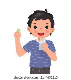 happy little boy taking a medicine pill with a glass of water