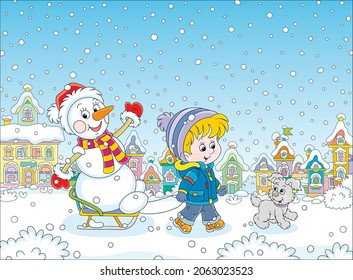 Happy little boy walking with his merry pup and sledding a funny snowman down a snow-covered street of a pretty small town on a beautiful snowy winter day, vector cartoon illustration