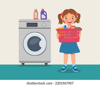 happy little girl holding basket full of clothes doing laundry daily chores with washing machine 