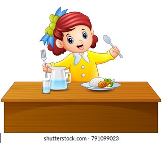 Happy little girl holding spoon and fork eating at the table