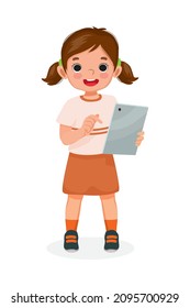 Happy little girl holding and using digital tablet touching screen browsing internet, doing homework, and playing games. Kids and electronic gadget devices concept for children.