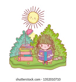 happy little girl reading books in the field