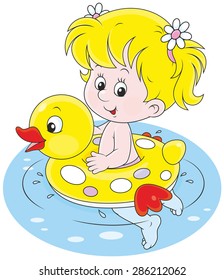 Happy little girl swimming with an inflatable rubber ring