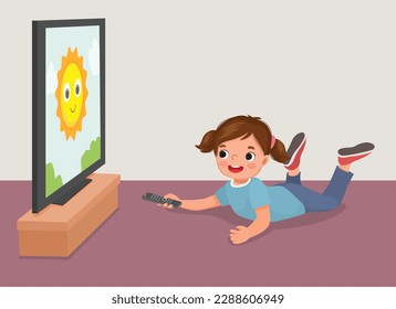 Happy little girl watching TV holding remote lying on the floor