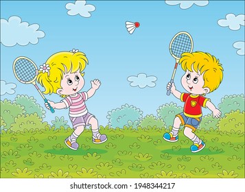 Happy little kids playing badminton with rackets and a flying shuttlecock in a fun game on a green playground in a summer park, vector cartoon illustration