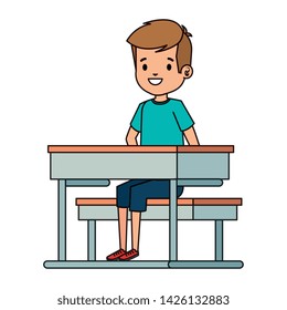 happy little student boy seated in school desk