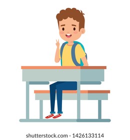 happy little student boy seated in school desk