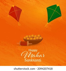Happy Makar Sankranti Concept With Bowl Full Of Indian Sweet Balls (Laddu), String Spool And Kites On Orange Grunge Background.