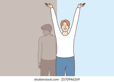 Happy man celebrating recovery from depression and restoration of mental health, standing near sad shadow. Psychological recovery of guy who recovered from prolonged stress and depression