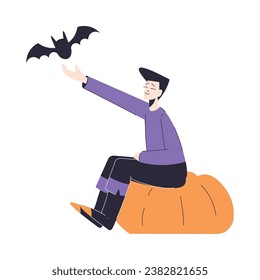 Happy Man Character at Halloween Party Sitting on Pumpkin with Bat Vector Illustration