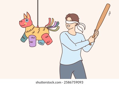 Happy man hitting pinata with baseball bat while trying to get candy at birthday party. Pinata in form of multi-colored horse hangs in front of blindfolded guy during festive mexican competition