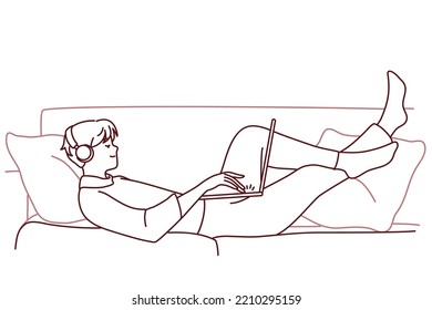 Happy man lying on couch wear headphones work on laptop. Smiling guy relax on sofa at home listen to music in earphones using computer. Vector illustration. 