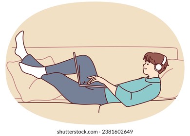 Happy man lying on couch wear headphones work on laptop. Smiling guy relax on sofa at home listen to music in earphones using computer. Vector illustration.