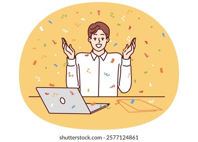 Happy man office worker with laptop raises hands up as sign of success and sits among falling confetti. Happy business man enjoying moment after making successful deal with partners