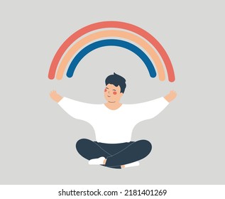 Happy man sits in yoga lotus pose with outstretched arms to create positive vibes around him. Teenage male open his arms to the rainbow and enjoys his life freedom. Mental health wellbeing concept.