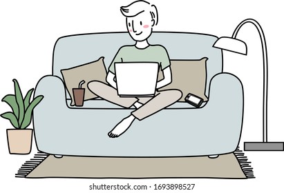 Happy man sitting with legs crossed on couch and using laptop. Work From Home concept with young man using computer on sofa. Man sitting comfortably on couch, typing on laptop keyboard at home.