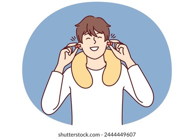 Happy man uses earplugs and neck pillow to rest during long journey on bus or plane. Positive guy traveler is in good mood after getting enough sleep on train