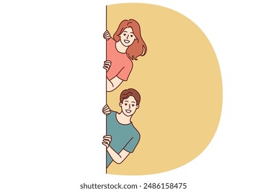 Happy man and woman with white banner peeking out recommending to pay attention to good advertisement offer. Young couple of guy and girl holding billboard for commercial or discount advertisement