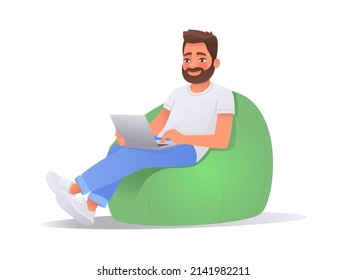 Happy man working on a laptop computer while sitting in a bean bag chair over isolated background. Freelancer guy working at home. Vector illustration in cartoon style