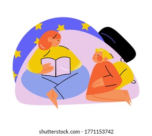 Happy mother and daughter having rest and reading book in pillow house