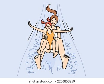 Happy mother and daughter screaming for joy going down water slide in aquapark for children recreation. Girl together with mom are relaxing in pool enjoying joint rest in aquapark