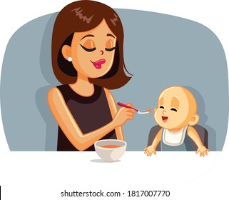 Happy Mother Feeding Her Baby Solid Food with a Spoon. Loving mom introducing new recipe to her child
