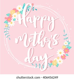 Happy mother's day lettering card. Floral circle frame on light pink background