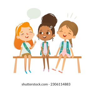 Happy multiethnic mixed age scout girls are sitting on a bench and chatting. Girl Scouts happily talking smiling and laughing. Junior League Girls together. Junior Scout uniform