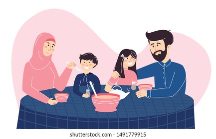 Happy Muslim family enjoying their meal together. Mother in hijab, a father and their son and daughter eating traditional food with tea. Islamic family holiday dinner and spending time at home.