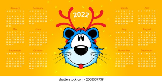 Happy new year 2022 calendar on yellow background. Cartoon blue tiger with red Christmas deer antlers 